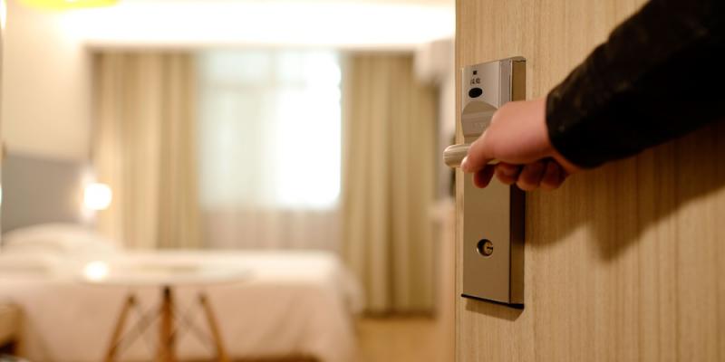 Person opening hotel door. Interstate Pest Management serving Portland OR & Vancouver WA talks about Going on a Summer Vacation? How to Avoid Bed Bugs When Traveling