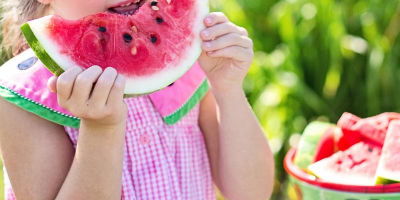 Little girl eating a watermelon slice. Interstate Pest Management serving Portland OR & Vancouver WA talks about 7 tips to deal with bugs.