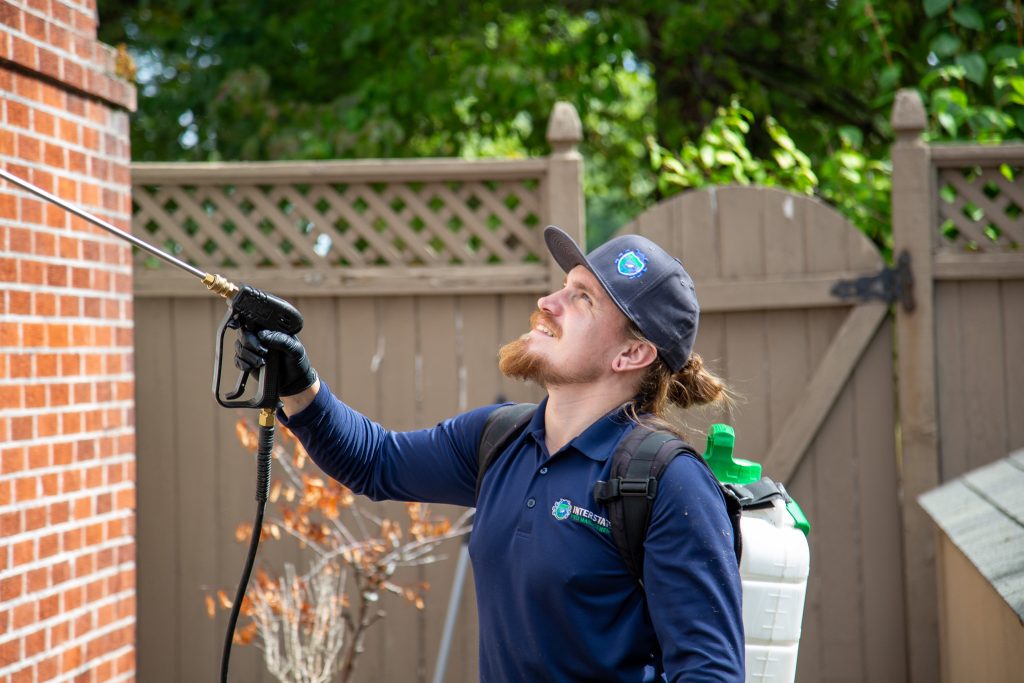 Interstate Pest Management technician performing spider control treatment at a home in Longview, WA.